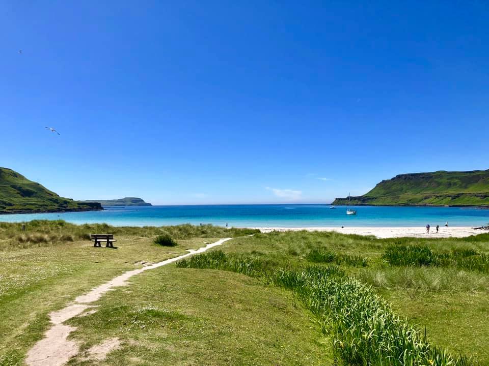 Sandy path leads through the sand dunes and grassland to Calgary Bay, with turquoise sea and blue skies.