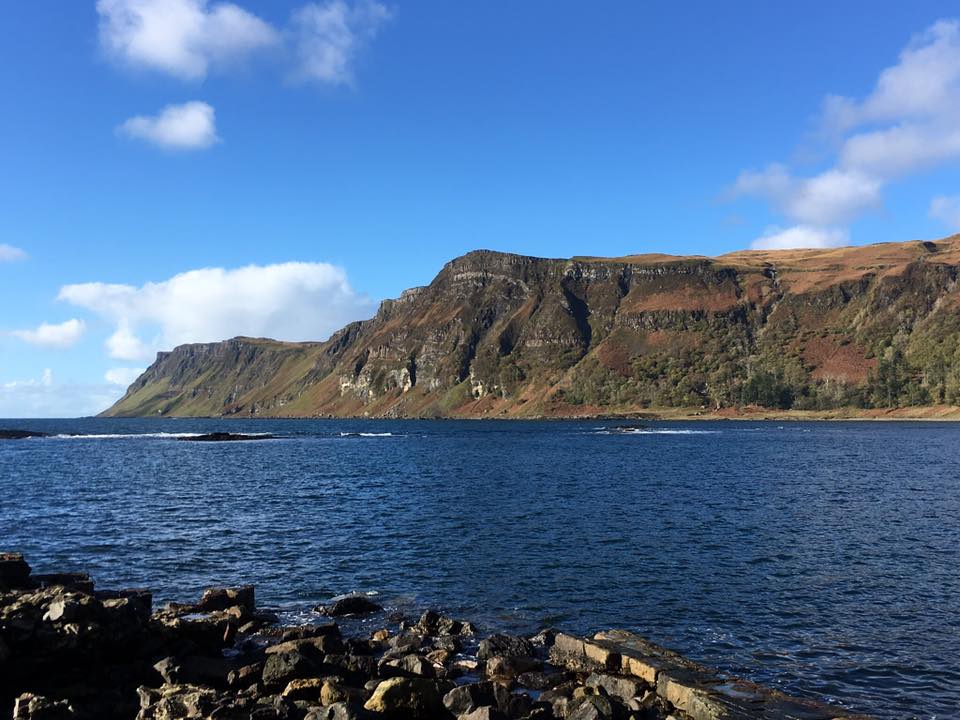 turquoise blue sea loch leading to rocky ridge and blue skies on Mull