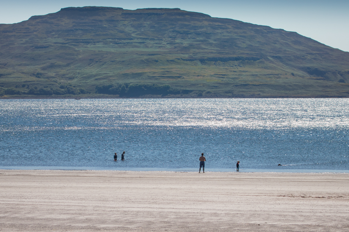 Wild swimmers enter the sea at Traigh na Cille, the black beach on the Isle of Mull