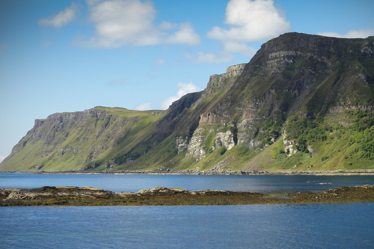 Carsaig Bay from sea level with lush green headland beyond