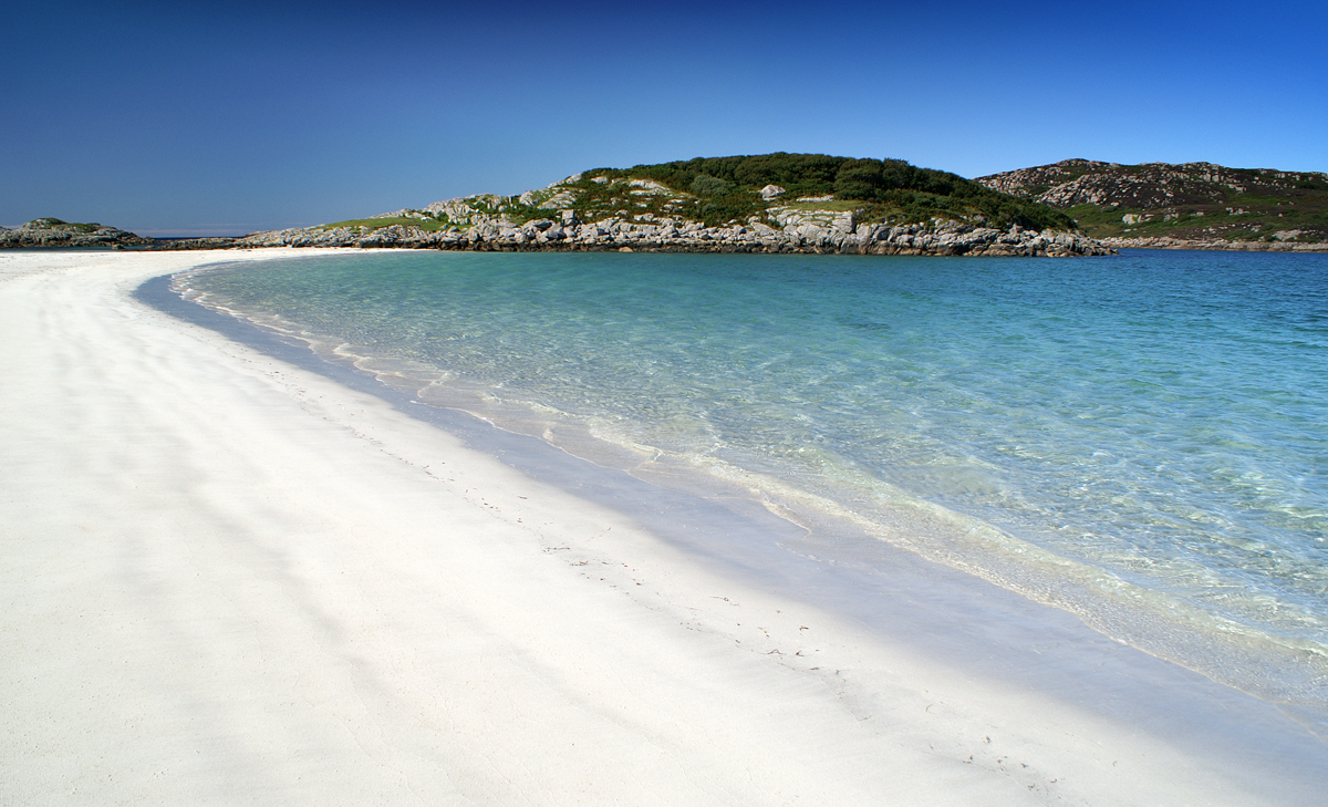 Sweeping white sand and calm turquoise sea at Knockvologan beach on the Isle of Mull