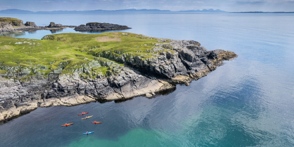 Group of kayakers by coast on Mull