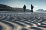 Walkers crossing Knockvologan beach to reach Erraid in winter