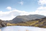 A walker following the ridges and lochan over Beinn Fhada