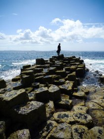 A person walking the basalt pavement on Staffa