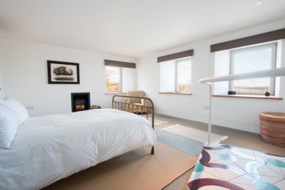 Double bedroom on ground floor with wood stove and seating