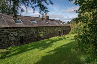 Mature gardens surround the cottage
