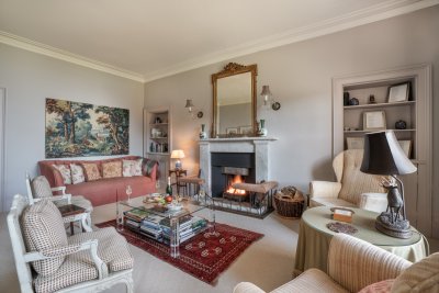 The formal reception room oozes character with antique furnishings and an open fire