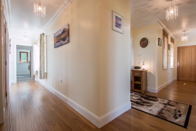 Lovely hallway with homely touches and wooden flooring