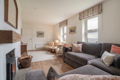 Looking across the living room with twin sitting areas and sea views