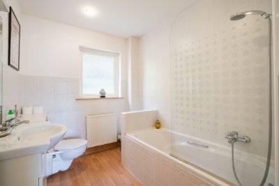 The family bathroom with bath and overhead shower, WC and basin
