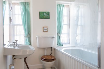 Bathroom with bath and shower over