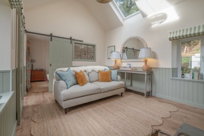 The beautifully presented living room at Mabel Cottage with quirky bedroom window