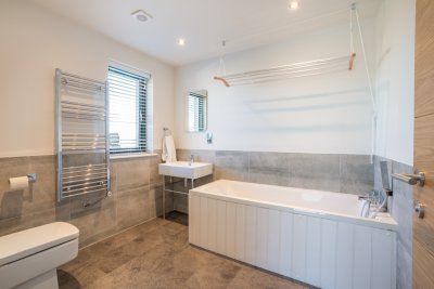 Family bathroom on the ground floor fitted with a bath with handheld shower, w.c, basin and heated towel rail