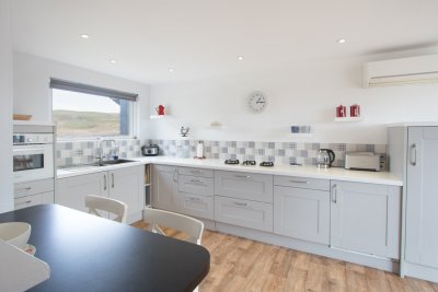 The breakfast bar offers a casual dining space, alongside the dining table in the sun room