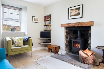 The cosy living room feels snug with the wood burner lit in the evening