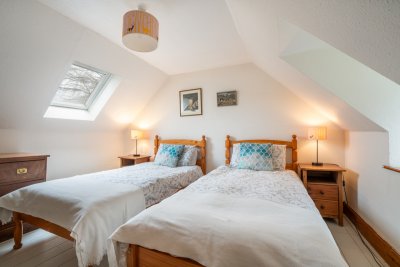 Upstairs, a twin bedroom beckons from beneath the eaves