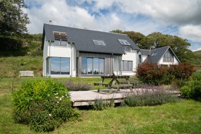 The large garden includes a decked seating area tucked within a wildflower lawn