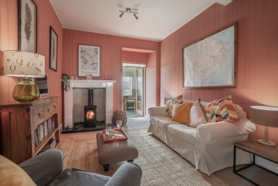 The living room feels ultra-cosy with wood burning stove and wood panelling