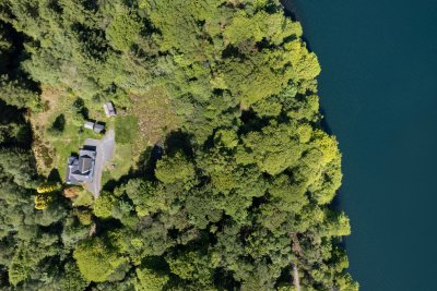 Looking down on Wood Cottage, the surrounding forest and the sea 