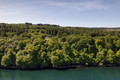 Wood Cottage peeks out between the trees overlooking the bay