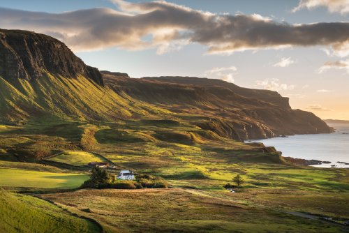 Balmeanach Farmhouse set beneath the cliffs on the dramatic coastline at Gribun