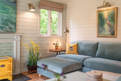 The living space is bathed in natural light and leafy views