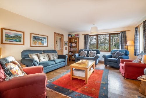 The living room feels every bit the heart of the home with plush furnishings and a well stocked bookcase