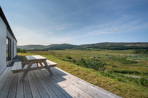 Decking wraps around the front of the house to take in the view over the river Bellart and loch Cuin