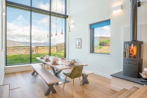 A dining area with a difference!  Impressive double-height ceiling with far-reaching views and wood burning stove