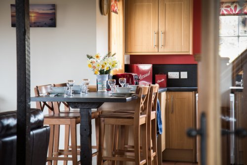 Gather around the sociable breakfast bar in the kitchen