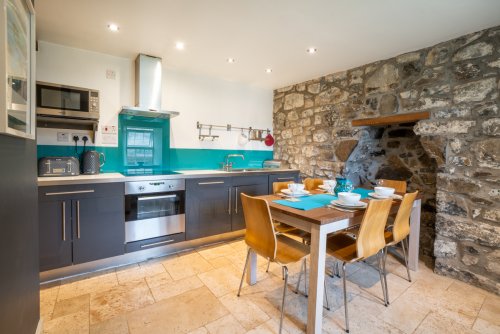 The cosy cottage kitchen with dining area and exposed stone walls