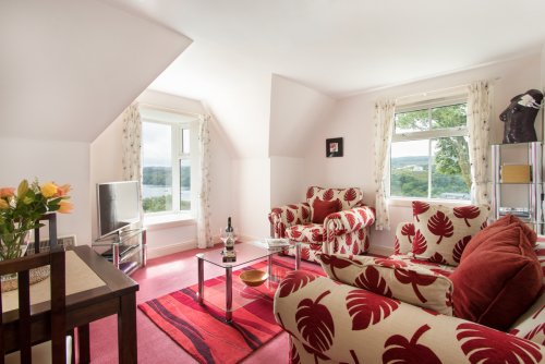 Living room with dual aspect windows, letting in lots of natural light, with excellent views of Tobermory harbour