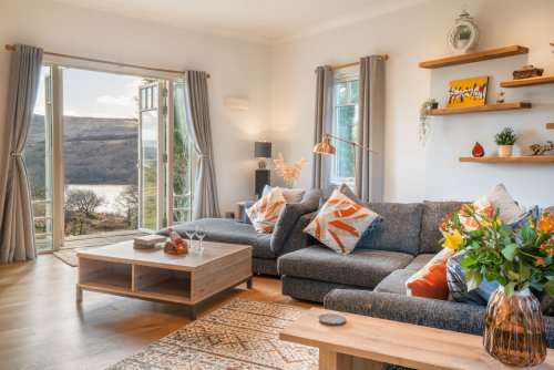 The open-plan living area makes the most of the sea view, with a cosy wood burning fireplace too