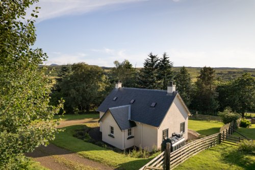 Prairie Cottage's pretty setting in a lawned garden with lots of trees