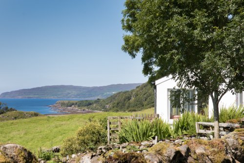 Tigh na Caora is close to the coast with fields and farmland in front of the house